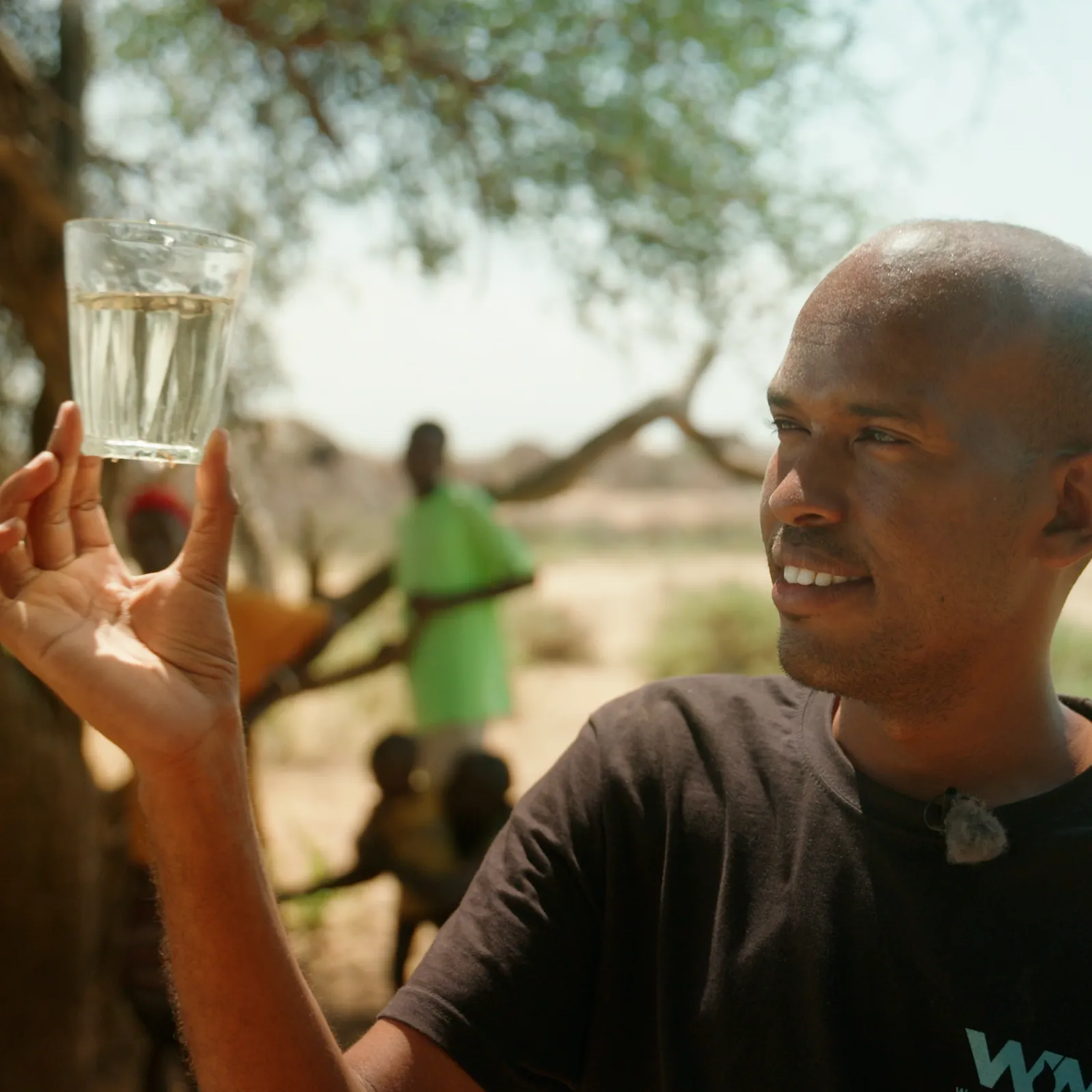 A person holding up a glass of clean filtered water